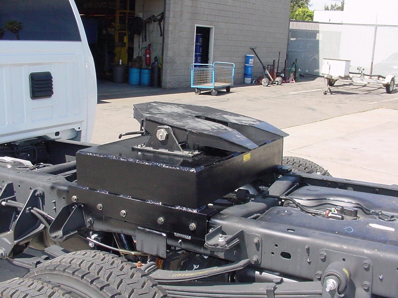 Heavy-duty 32,000 lb 5th wheel hitch installed in a truck bed with custom under-bed brackets for commercial hauling.