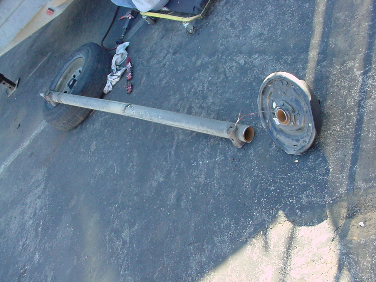 A damaged and bent trailer axle requiring replacement and repair.